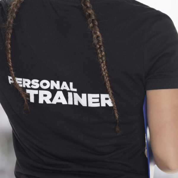 Female Personal Trainer, with his back facing the camera, looking at a gym